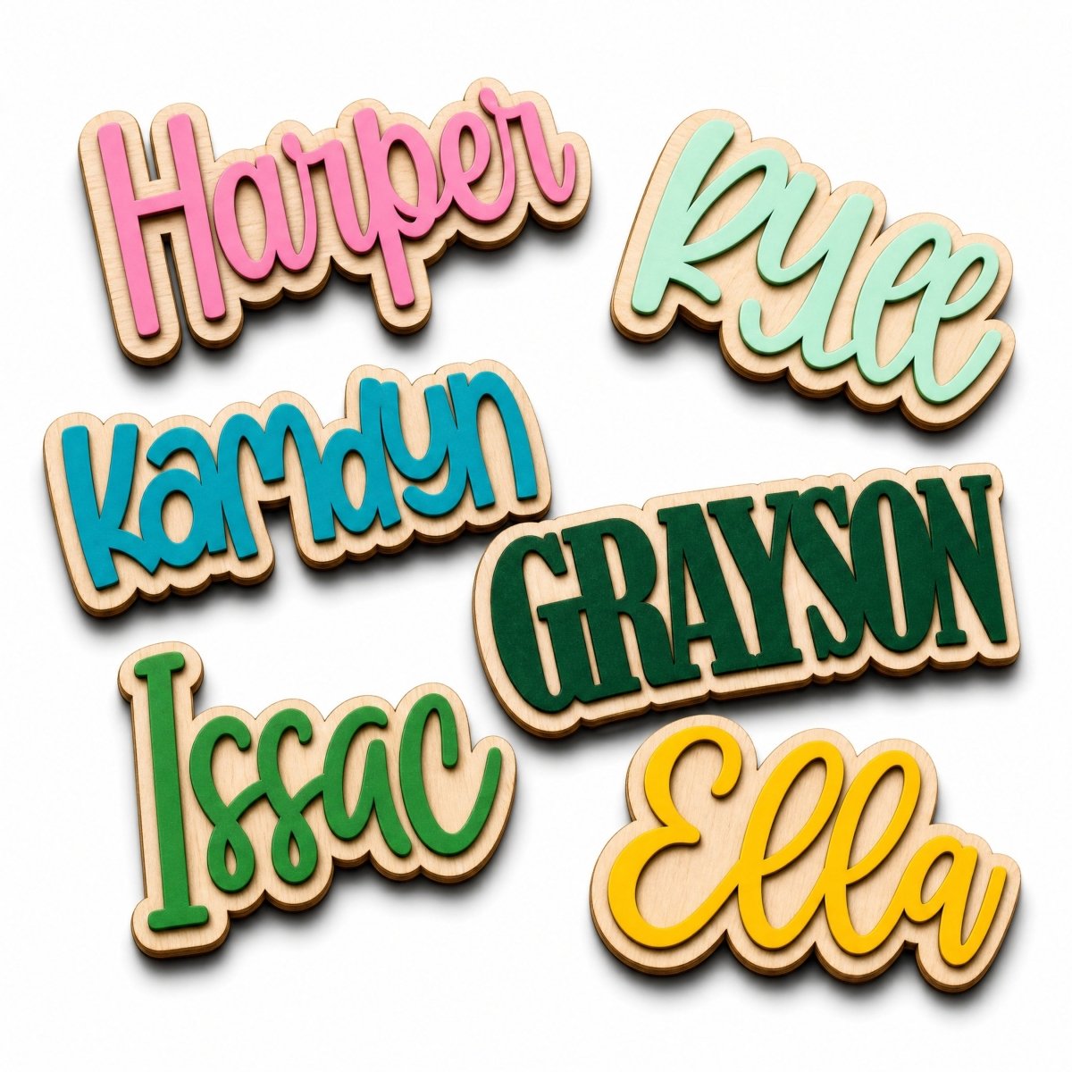 Six personalized wooden nameplates with cursive names (Harper, Kyece, Kamdyn, Grayson, Issac, Ella) in different colors, arranged on a white background.
