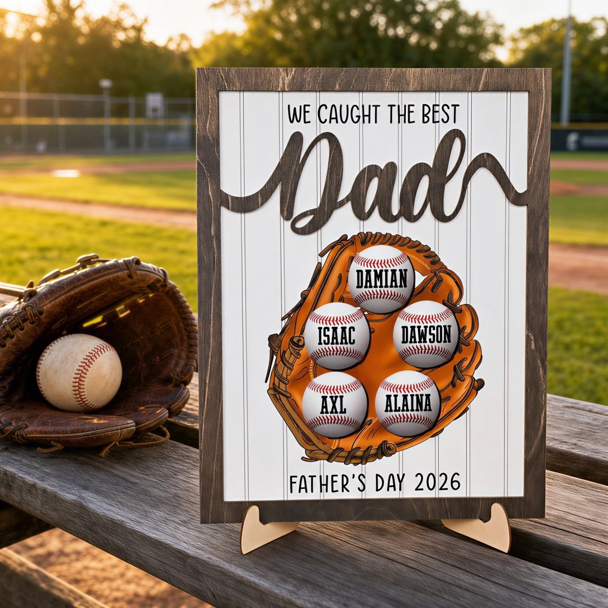 Personalized Father's Day baseball plaque for Dad. Custom wooden children's name sign featuring a 3D baseball glove, rustic frame, and five customized baseballs displayed outdoors against a baseball field.