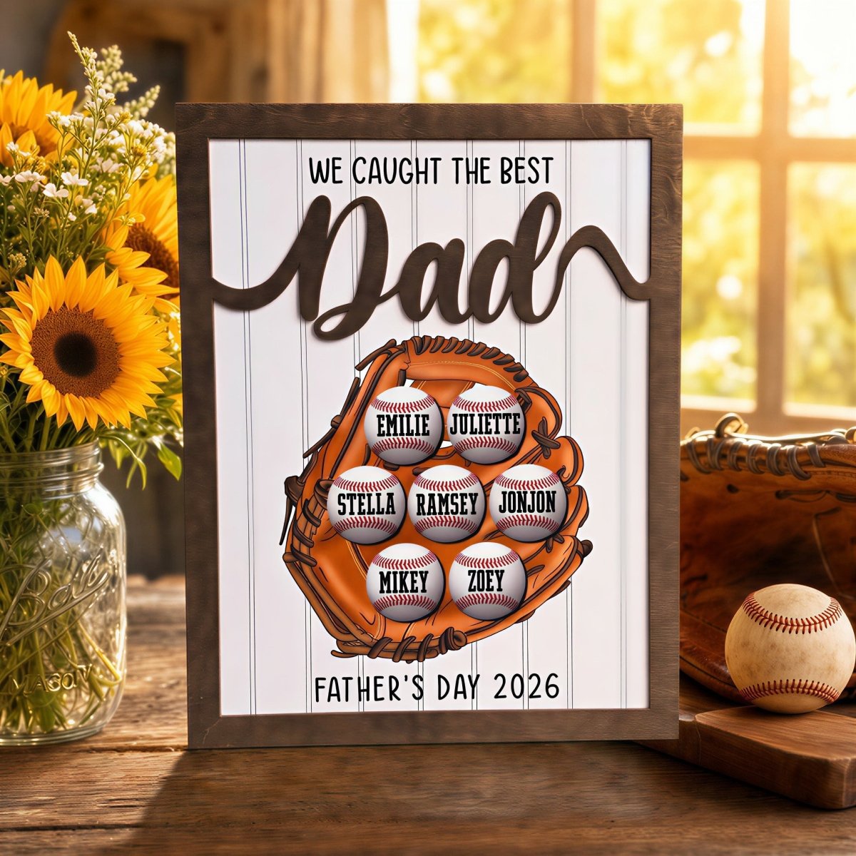 Personalized Father's Day baseball plaque for Dad. Features a rustic wood frame, 3D raised "Dad" lettering, and a printed baseball glove holding seven custom kids' name baseballs, displayed next to sunflowers.